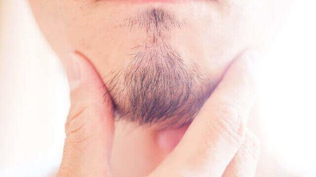 顎髭を触る男性